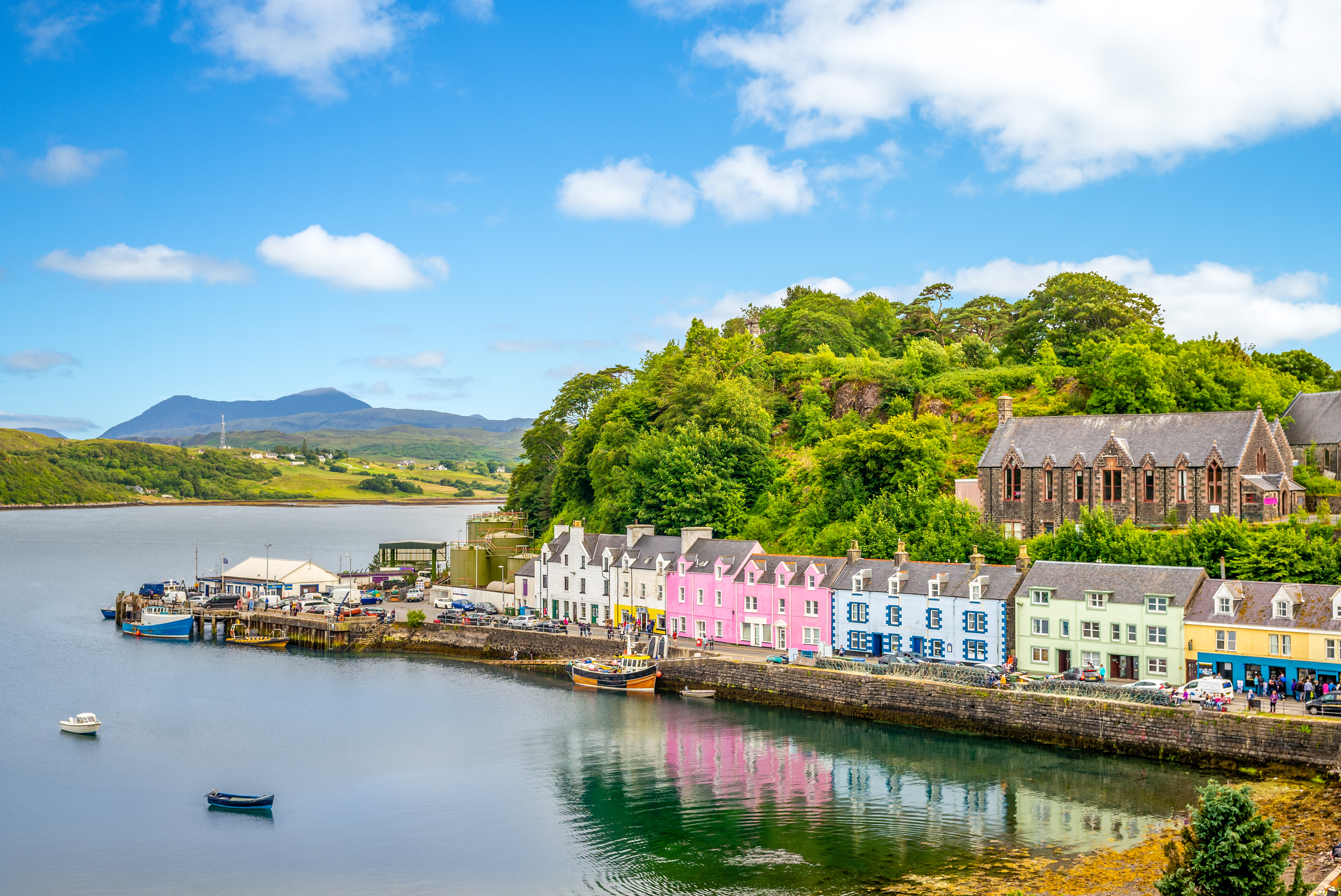 Portree harbour on the Isle of Skye, Scotland, featuring colourful houses and coastal scenery in the Scottish Highlands.
