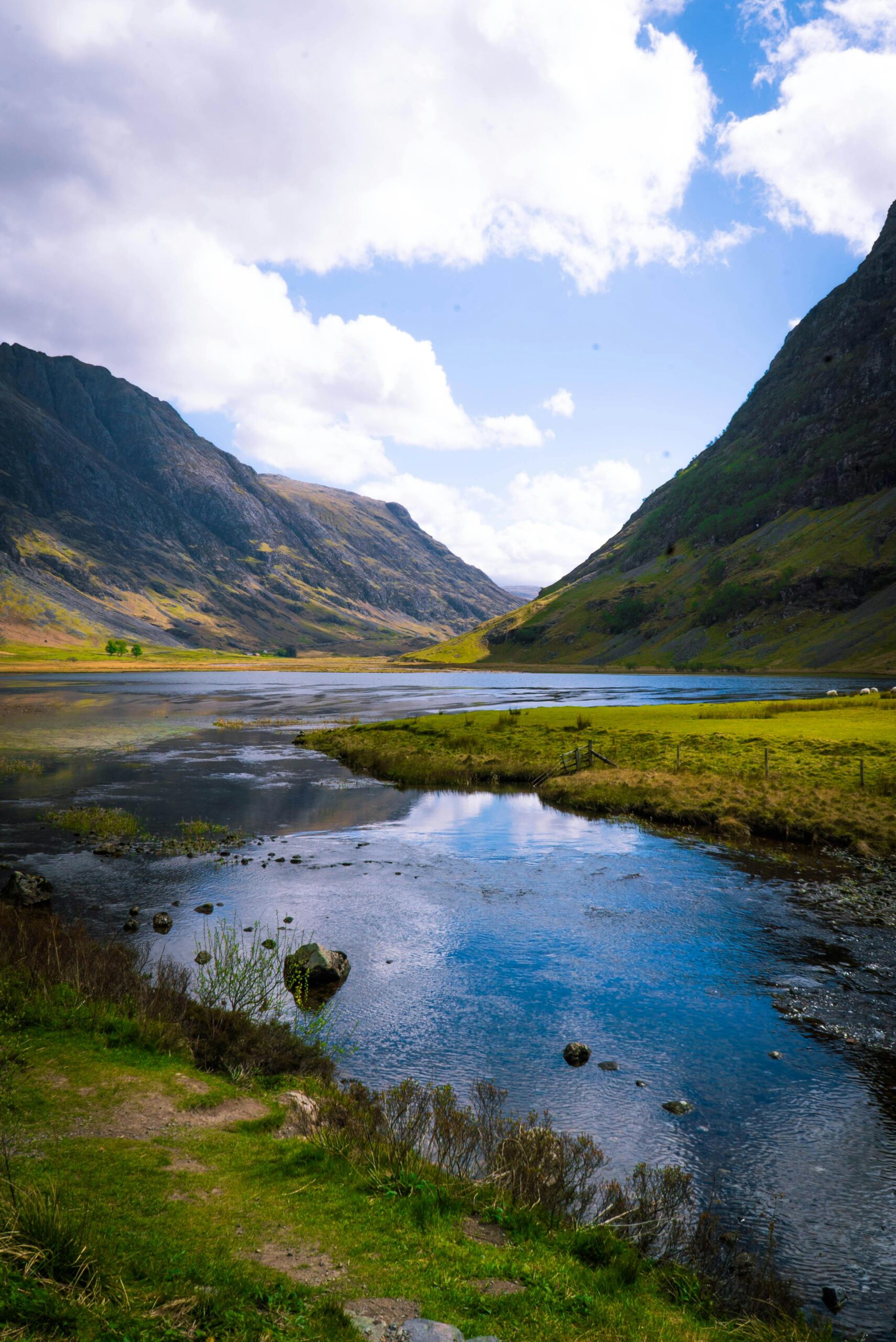 Breathtaking view of the Glencoe valley with a reflective lake in the Scottish Highlands under a sunny sky. Loch Achtriochtan Glencoe, whiste house glencoe